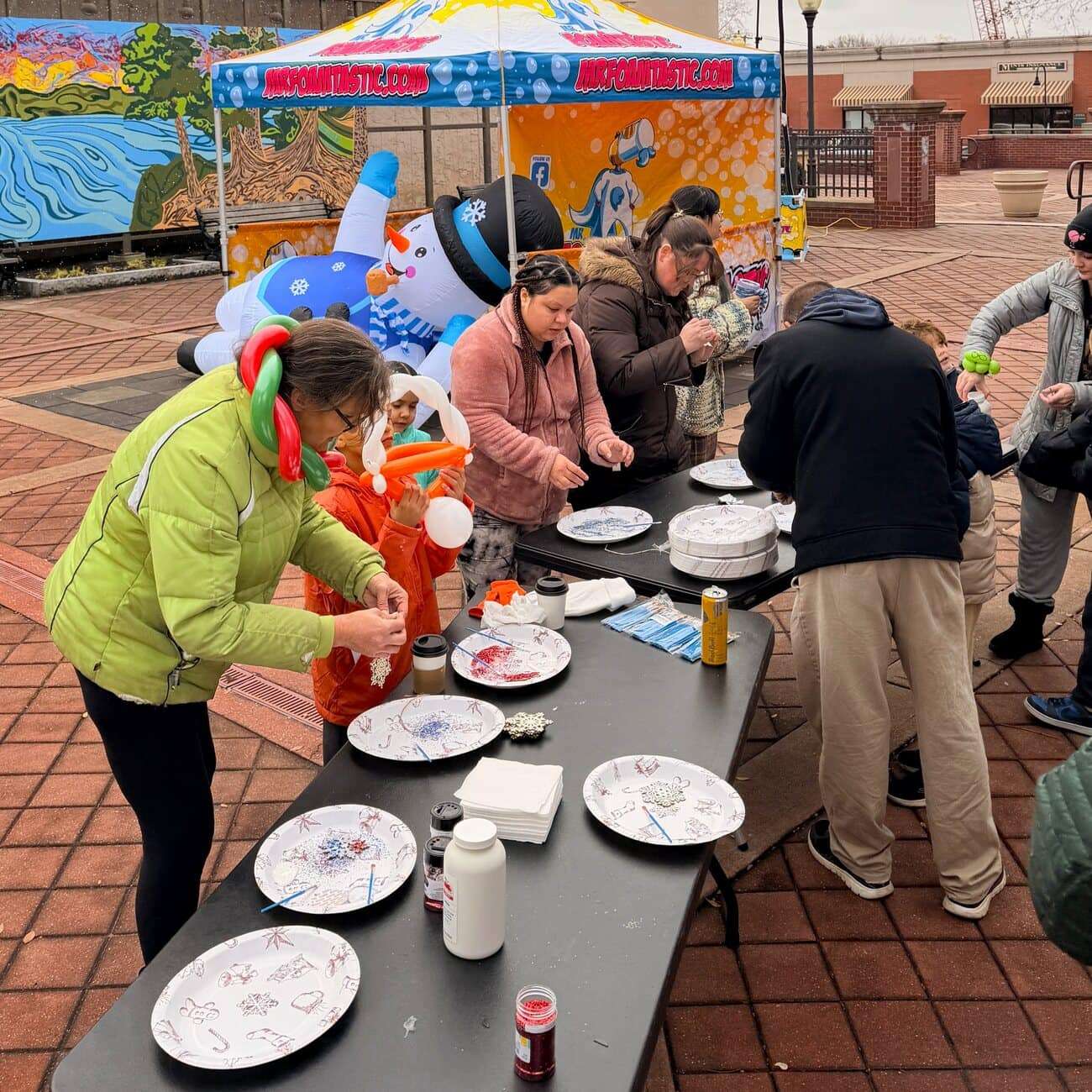 Kids painting snowflake ornaments at the Mr. Foamtastic craft station during a New Jersey winter event