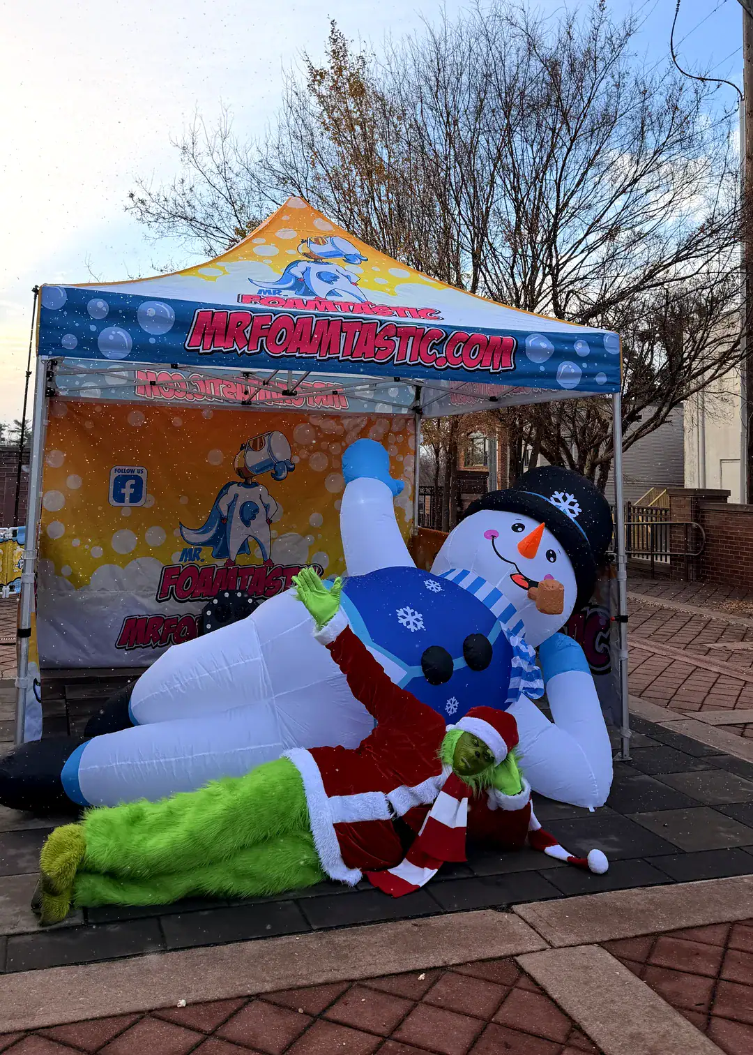 Giant snowman inflatable and the Grinch under the Mr. Foamtastic tent at a New Jersey holiday event